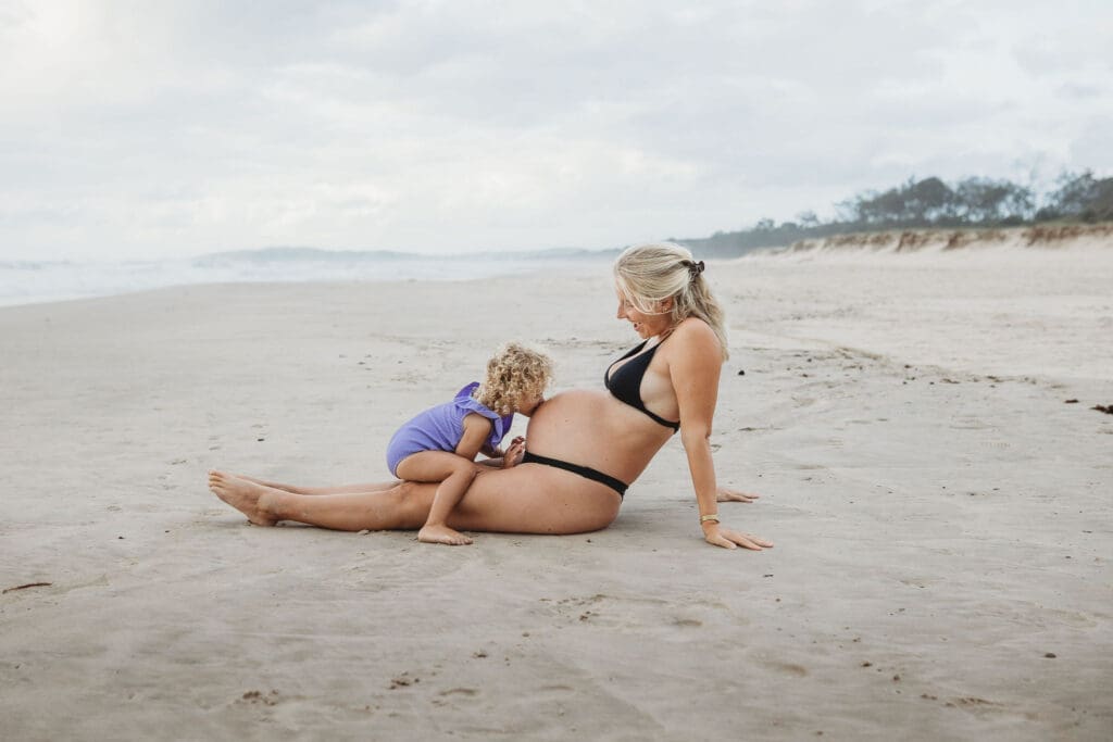 pregnant mummy and daughter at the beach in Byron Bay