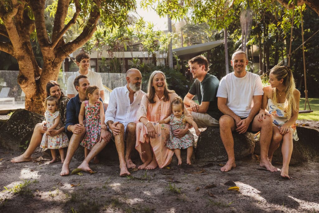 Large family group portrait in Byron Bay with grandparents, adult children and grandchildren on the beach